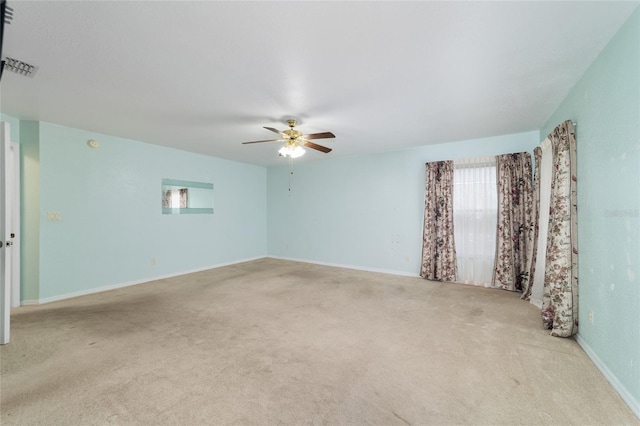 carpeted empty room with ceiling fan and baseboards