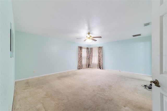 carpeted spare room with a ceiling fan and baseboards
