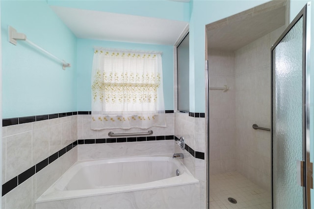 bathroom featuring a stall shower and a garden tub