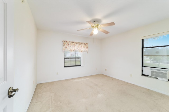 unfurnished room with healthy amount of natural light, cooling unit, light colored carpet, and a ceiling fan