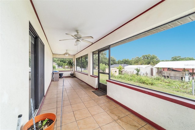 unfurnished sunroom with a ceiling fan