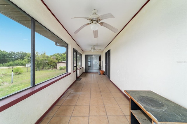 unfurnished sunroom with a ceiling fan