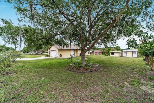 view of grassy yard featuring driveway and an attached garage