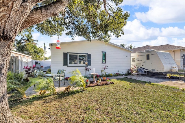 back of property with a yard, fence, and a patio