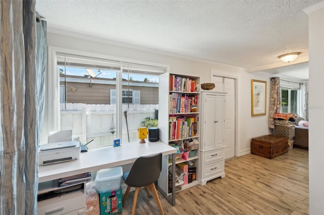 office space featuring light wood-type flooring and a textured ceiling