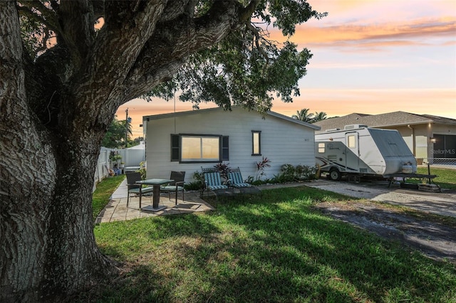 rear view of property with a yard, fence, and a patio area