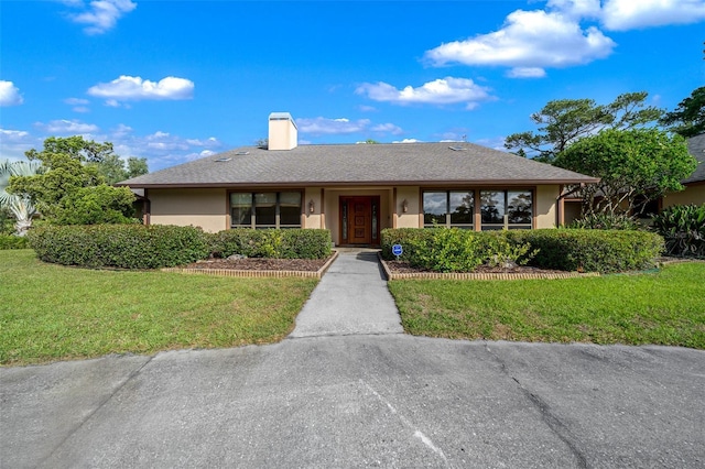 5950 SW 21st Avenue Rd, Ocala, FL 34471 - ranch-style house with a chimney, a front lawn, and stucco siding