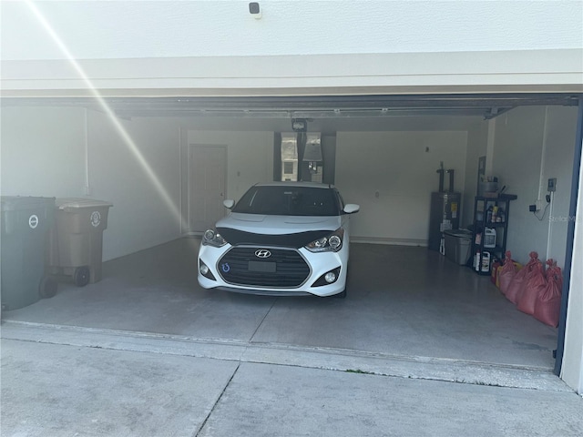 garage featuring driveway and water heater