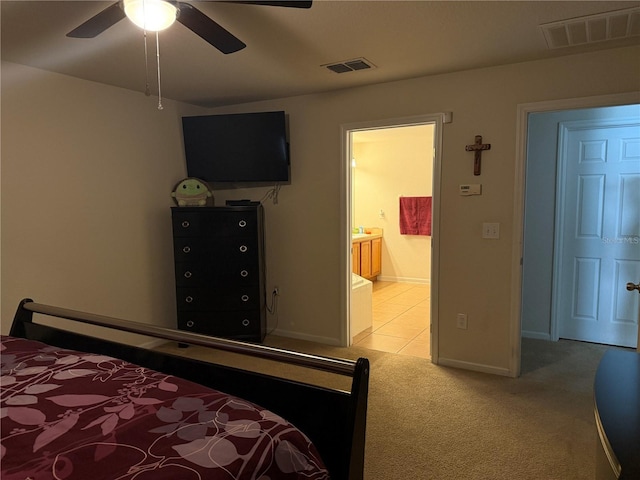 bedroom with light colored carpet, baseboards, ensuite bathroom, and ceiling fan