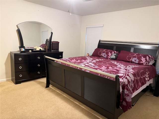 bedroom with light carpet and baseboards