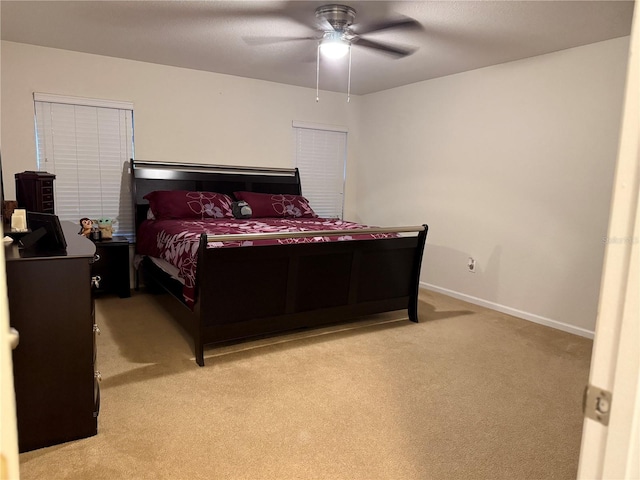 bedroom with light carpet, baseboards, and ceiling fan