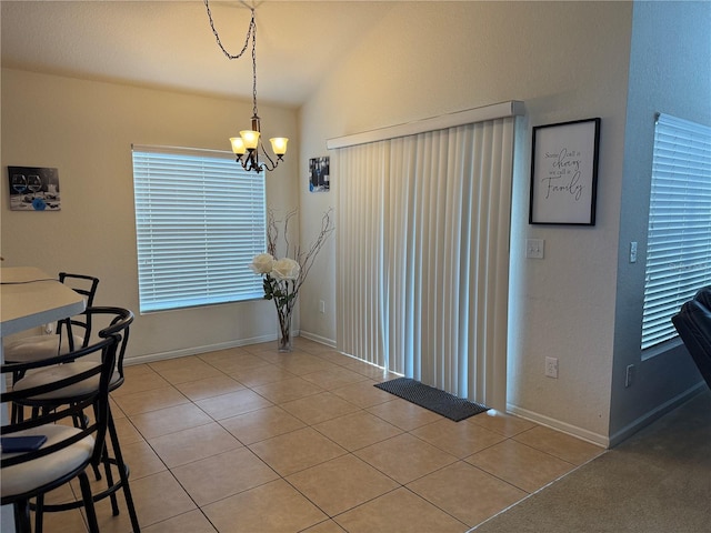 dining area with a chandelier, light tile patterned flooring, lofted ceiling, and baseboards