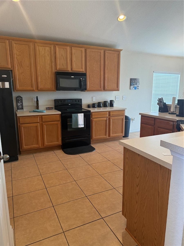 kitchen featuring black appliances, light countertops, light tile patterned floors, brown cabinetry, and recessed lighting