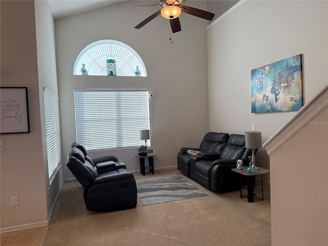 carpeted living area with ceiling fan, high vaulted ceiling, and baseboards