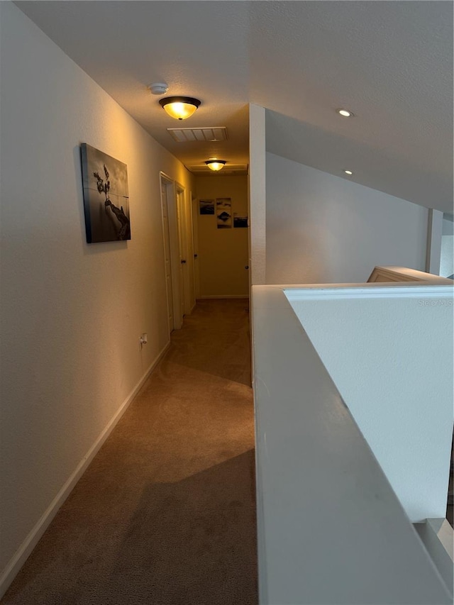 hallway featuring carpet floors and baseboards
