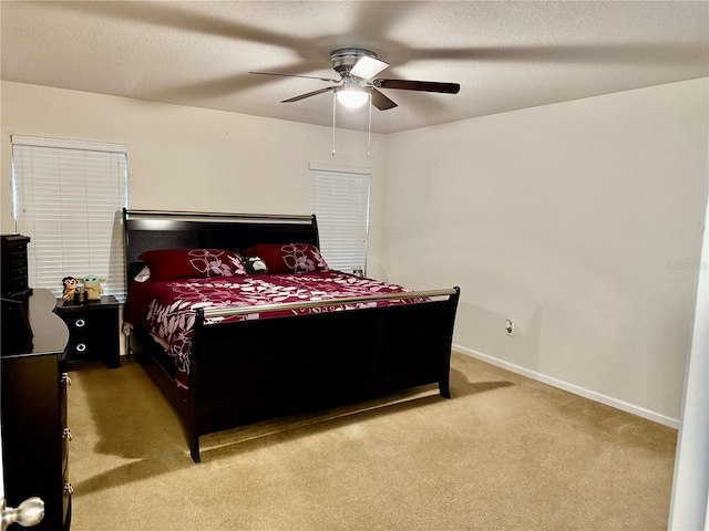 bedroom with light carpet, baseboards, and a ceiling fan