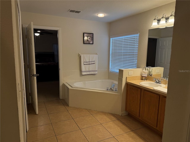 full bathroom with tile patterned flooring, a garden tub, and vanity