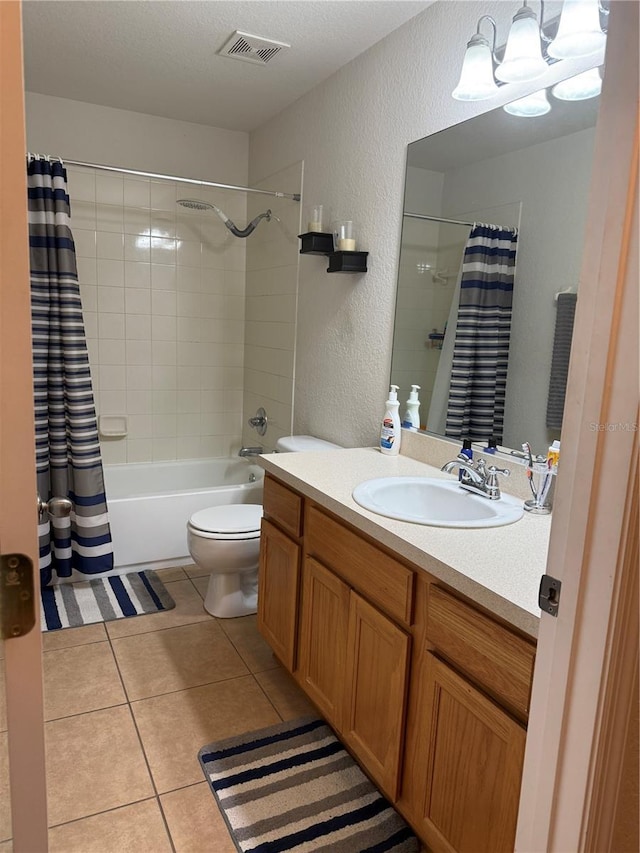 bathroom featuring a textured wall, toilet, tile patterned floors, vanity, and shower / tub combo