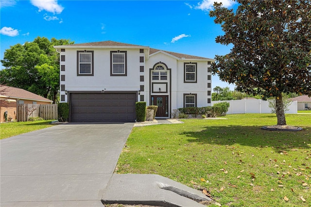 view of front of property with a front yard, concrete driveway, stucco siding, fence, and an attached garage