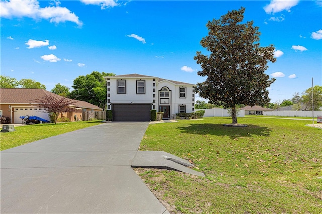 view of front of house with driveway, stucco siding, fence, a front lawn, and a garage