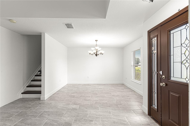 entryway with baseboards, visible vents, stairway, and a chandelier