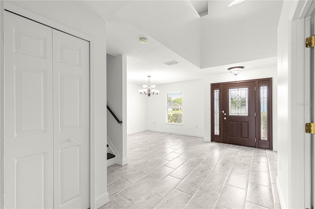 entryway with baseboards, visible vents, stairway, and a notable chandelier