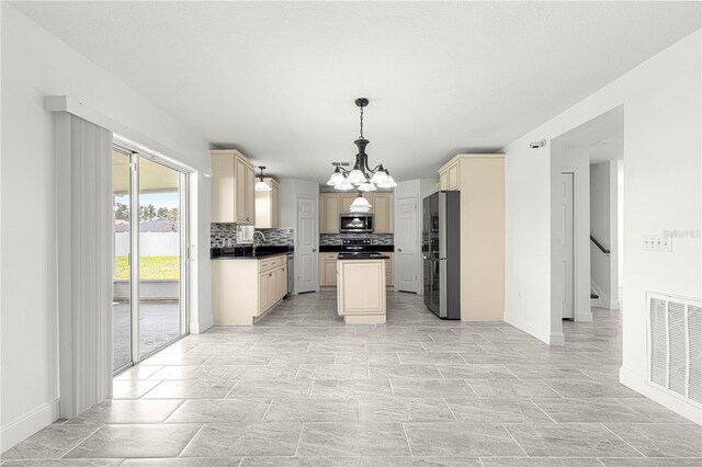 kitchen with stainless steel appliances, visible vents, cream cabinetry, decorative backsplash, and an inviting chandelier