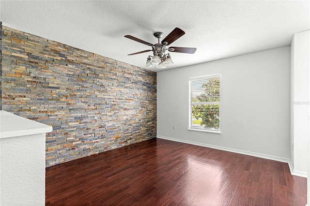 unfurnished room with a textured ceiling, ceiling fan, and wood finished floors
