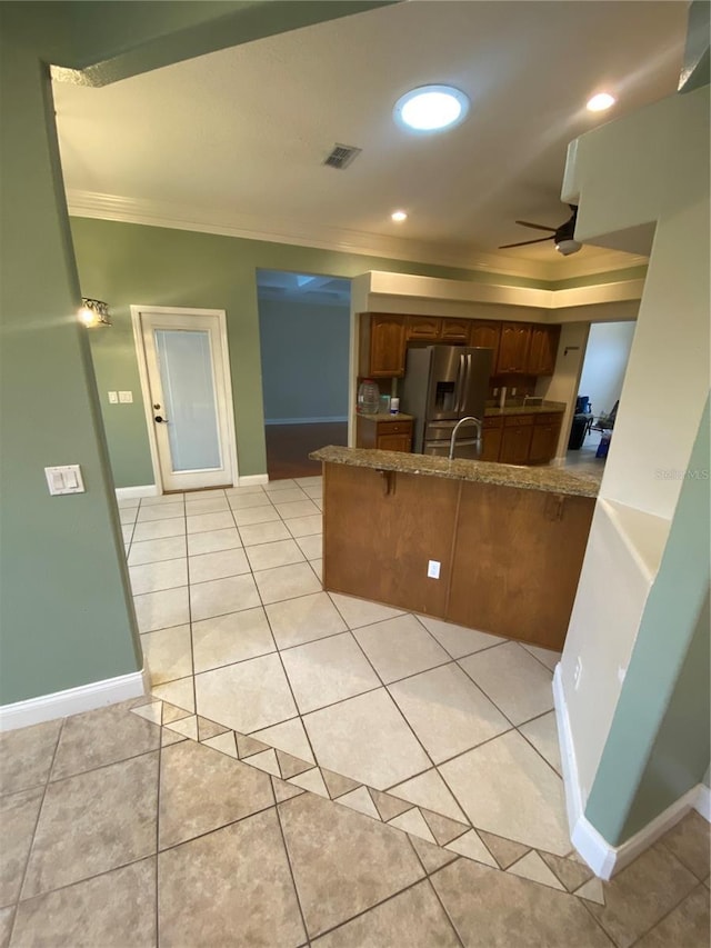5323 SW 111th Lane Rd, Ocala, FL 34476 - kitchen with a peninsula, crown molding, stainless steel refrigerator with ice dispenser, baseboards, and ceiling fan