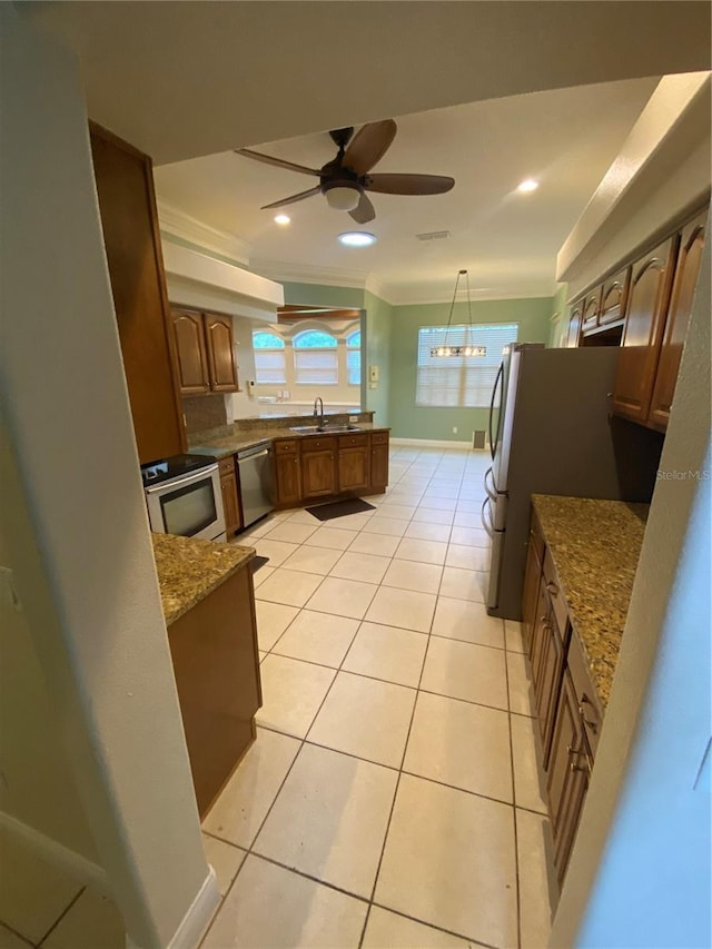 5323 SW 111th Lane Rd, Ocala, FL 34476 - kitchen with stainless steel appliances, a sink, crown molding, dark stone counters, and light tile patterned flooring