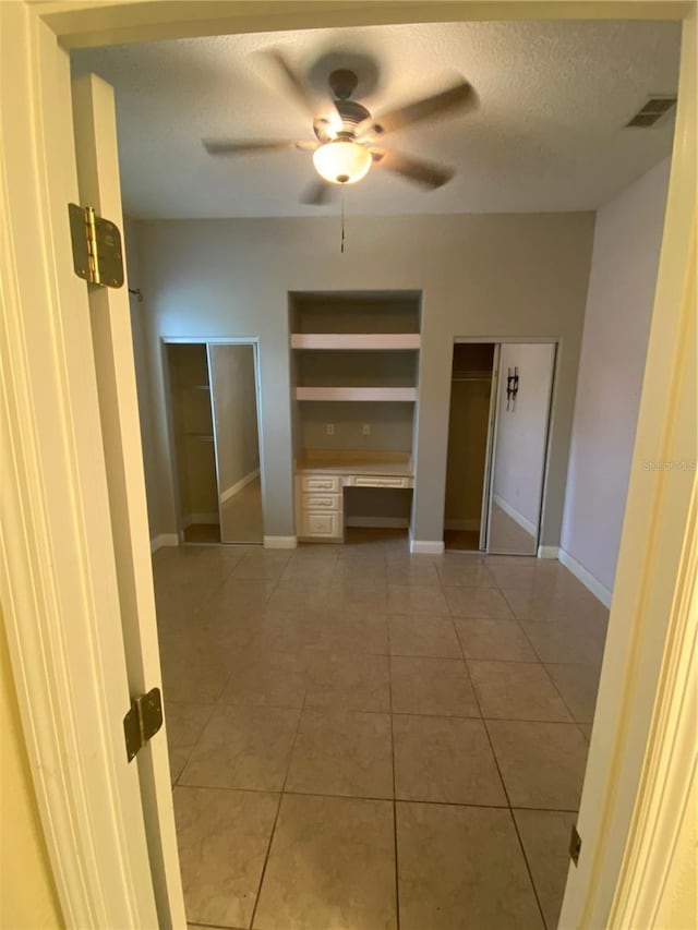 5323 SW 111th Lane Rd, Ocala, FL 34476 - hallway with a textured ceiling, light tile patterned flooring, and baseboards