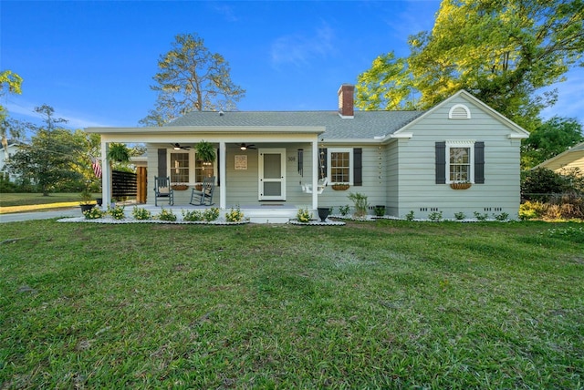 ranch-style home with a ceiling fan, a chimney, a front lawn, and a porch