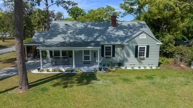view of front of property with a chimney, a porch, roof with shingles, and a front lawn