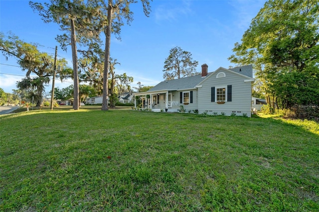 ranch-style home featuring a front lawn, a chimney, and a porch