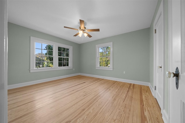 spare room with light wood-style flooring, ceiling fan, and baseboards