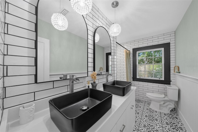 full bath with a chandelier, toilet, a wainscoted wall, vanity, and tile patterned floors