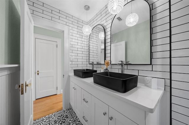full bathroom with a chandelier, tasteful backsplash, and double vanity