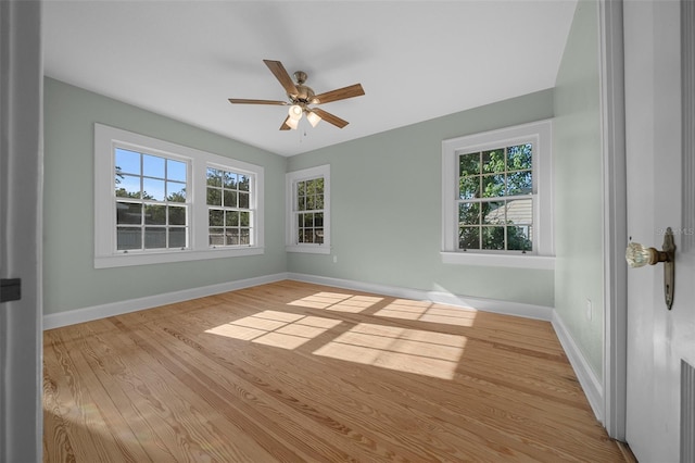 spare room featuring baseboards, wood finished floors, and ceiling fan