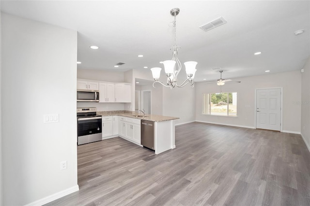 5 Malauka Radial Trak, Ocklawaha, FL 32179 - kitchen featuring white cabinetry, open floor plan, stainless steel appliances, light wood-style floors, and visible vents