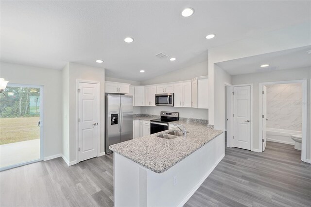5 Malauka Radial Trak, Ocklawaha, FL 32179 - kitchen with a peninsula, stainless steel appliances, visible vents, white cabinets, and light wood-style floors