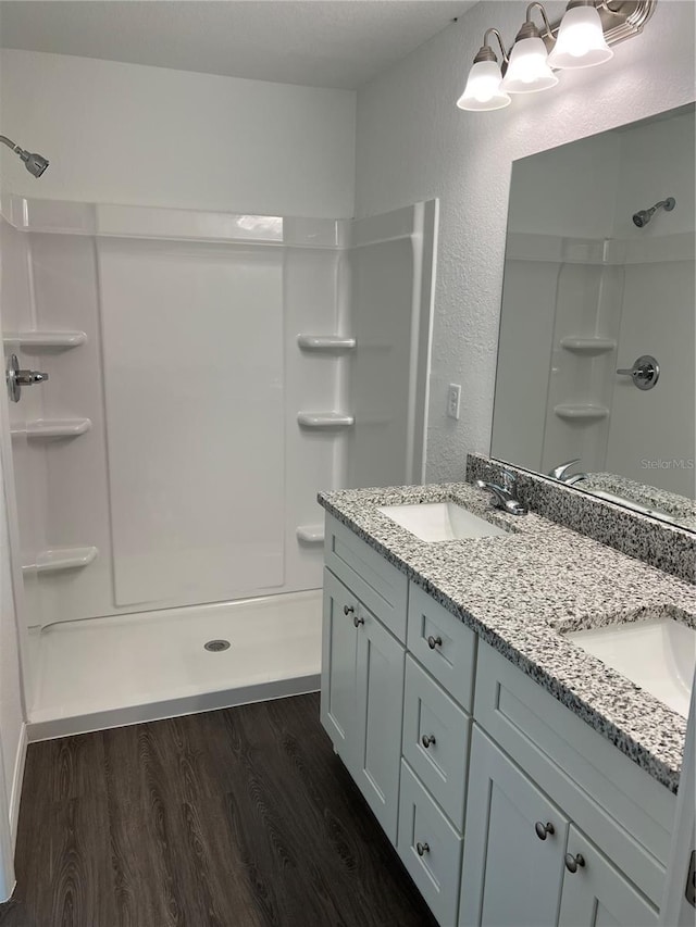 5 Malauka Radial Trak, Ocklawaha, FL 32179 - full bath featuring double vanity, wood finished floors, a sink, a stall shower, and a textured wall