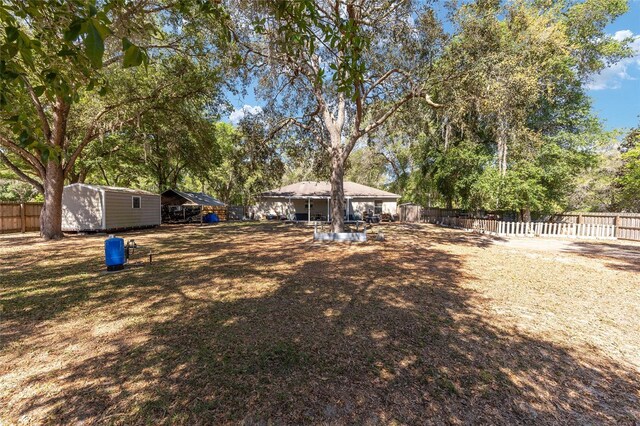 5855 SE 158th Ct, Ocklawaha, FL 32179 - view of yard with a fenced backyard, an outdoor structure, and a storage unit
