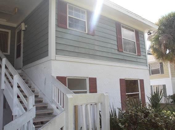 view of property exterior featuring stucco siding and stairs
