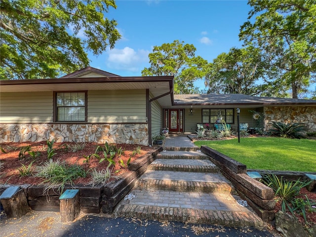 4085 SE 23rd Ter, Ocala, FL 34480 - view of front of home featuring stone siding, a front yard, and covered porch