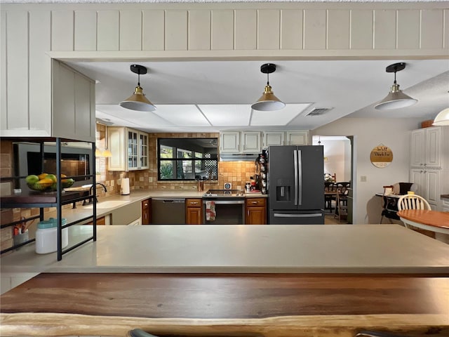 4085 SE 23rd Ter, Ocala, FL 34480 - kitchen with stainless steel appliances, under cabinet range hood, backsplash, light countertops, and glass insert cabinets
