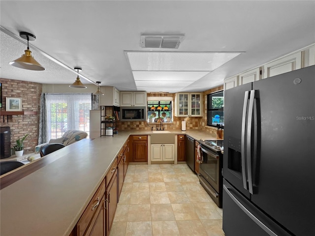 4085 SE 23rd Ter, Ocala, FL 34480 - kitchen featuring black appliances, light countertops, tasteful backsplash, glass insert cabinets, and hanging light fixtures