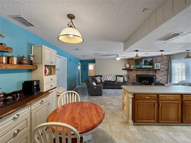 4085 SE 23rd Ter, Ocala, FL 34480 - kitchen with a textured ceiling, a fireplace, a ceiling fan, pendant lighting, and open floor plan