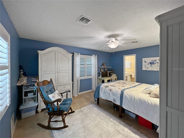 4085 SE 23rd Ter, Ocala, FL 34480 - bedroom featuring multiple windows, a textured ceiling, ceiling fan, and connected bathroom