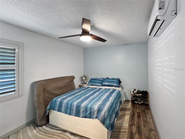 4085 SE 23rd Ter, Ocala, FL 34480 - bedroom with a wall unit AC, a ceiling fan, a textured ceiling, and wood finished floors