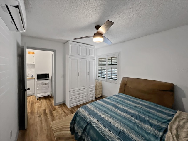 4085 SE 23rd Ter, Ocala, FL 34480 - bedroom with a wall unit AC, light wood finished floors, a textured ceiling, ceiling fan, and a closet